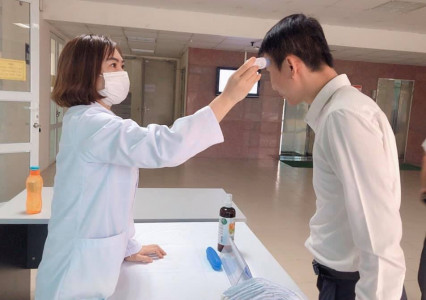 HUNRE đo thân nhiệt và phát khẩu trang miễn phí cho cán bộ và khách đến làm việc